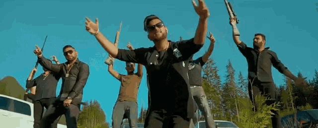 a group of men are holding guns in their hands and dancing