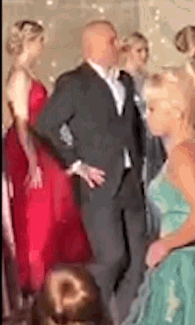 a man in a suit and tie is standing next to a woman in a red dress at a prom .