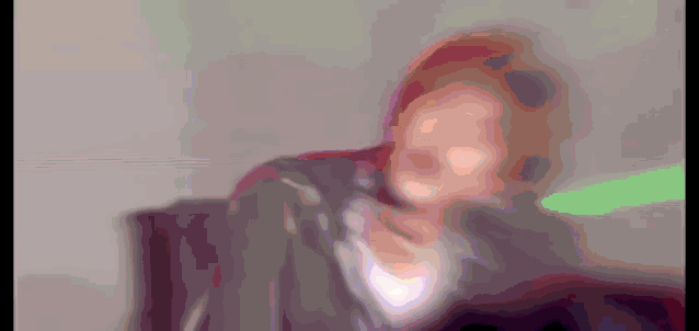 a blurry picture of a person holding a green lightsaber .