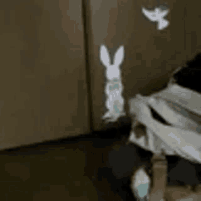 an owl and a rabbit are standing next to each other on the floor .