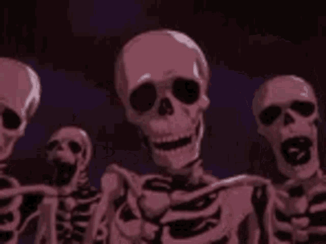 a group of skeletons are standing next to each other and looking at the camera .