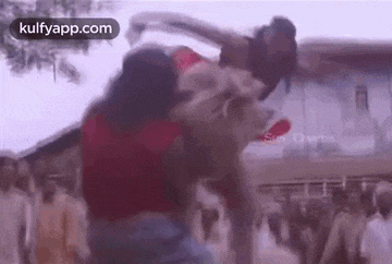 a man is carrying a woman on his back in a crowded street .