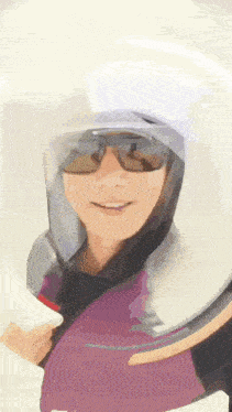 a woman wearing a helmet and sunglasses is smiling and looking at the camera .