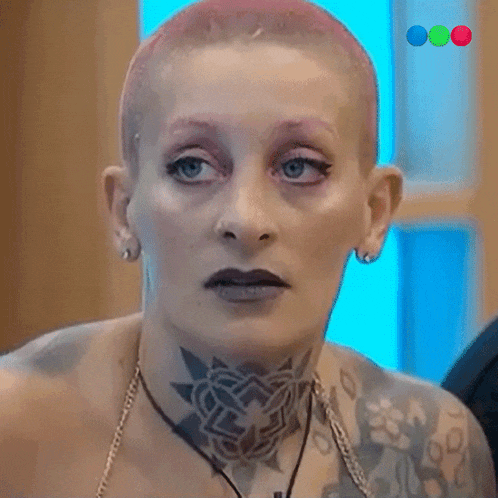 a woman with a shaved head and a lot of tattoos