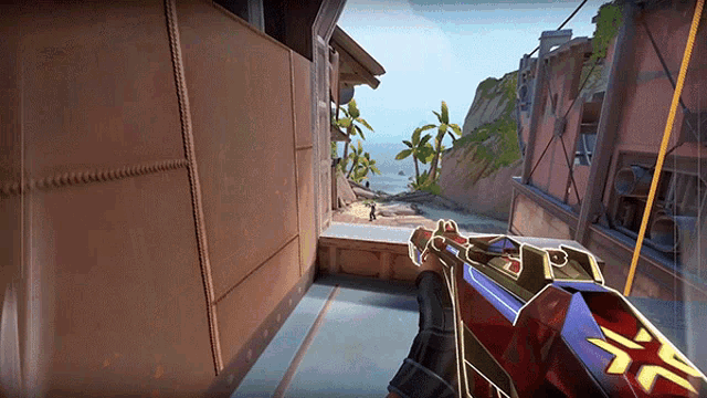 a person is holding a gun in front of a building with a cliff in the background .