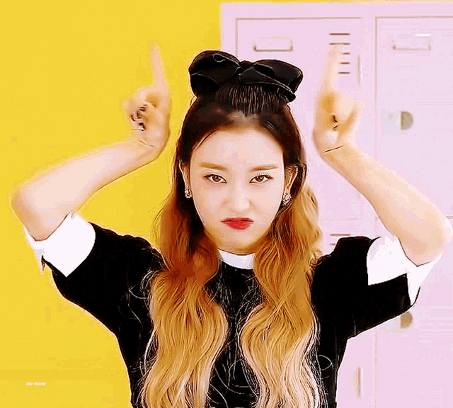 a girl with a black bow in her hair makes a funny face