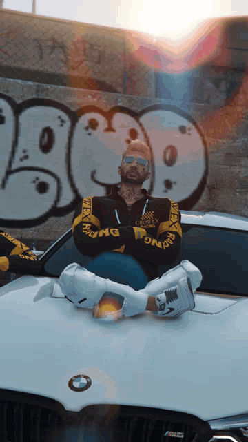 a man sitting on the hood of a bmw