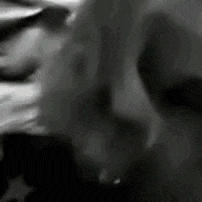a close up of a person 's face in a black and white photo with a blurred background .