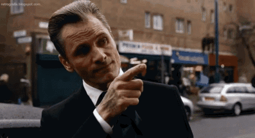 a man in a suit and tie is pointing his finger