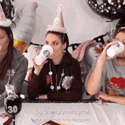 a woman wearing a starbucks hat drinks from a cup