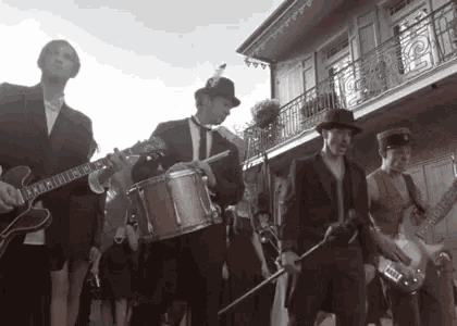 a black and white photo of a group of men playing instruments .