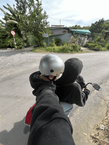 a person wearing a helmet is riding a motorcycle on a road