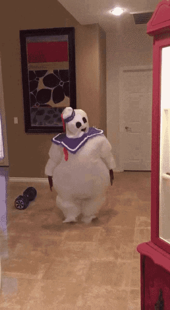 a person dressed as a ghostbuster is walking in a hallway