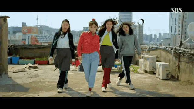 a group of girls are walking on a rooftop with sbs written on the bottom of the screen