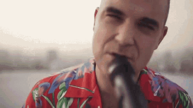 a close up of a man singing into a microphone