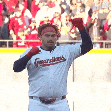 a man wearing a guardians jersey is standing on a baseball field