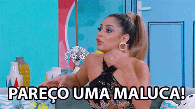 a woman is sitting on a couch with the words pareco uma maluca on the bottom