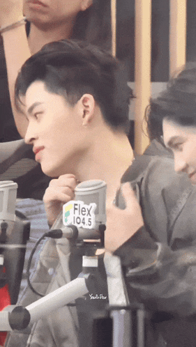 a man with a flex 104.5 sticker on a microphone