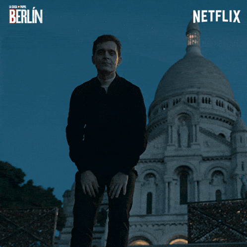 a man sits on a set of stairs in front of a building that says netflix berlin
