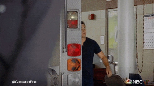 a man is standing in front of a fire truck with the hashtag #chicagofire