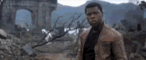 a man is standing in front of a bridge in a ruined city .