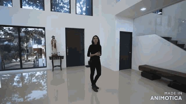 a video of a woman standing in a room with the words made in animatica on the bottom