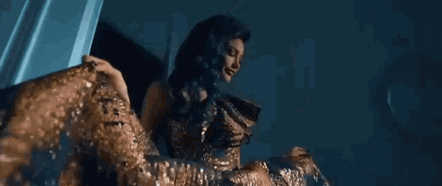 a woman in a gold dress is standing in a doorway dancing .