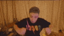 a man in a black shirt is dancing in a living room .