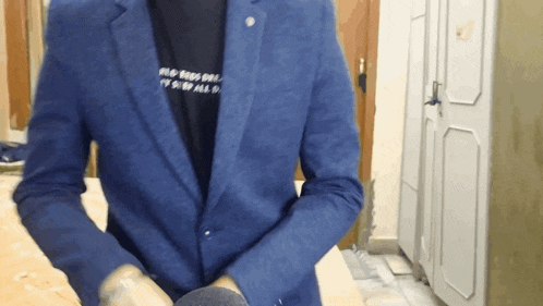 a man wearing a blue jacket and a black t-shirt that says old birds on it