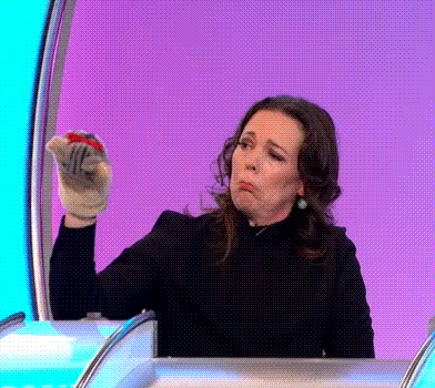 a woman is making a funny face while holding a glove in her hand .