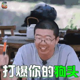 a man wearing glasses is sitting at a table with chinese writing on it