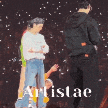 a group of people standing on a stage with the word artistae on the bottom right