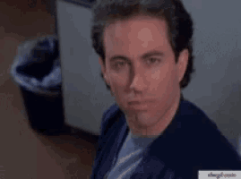 a man is making a funny face in front of a trashcan