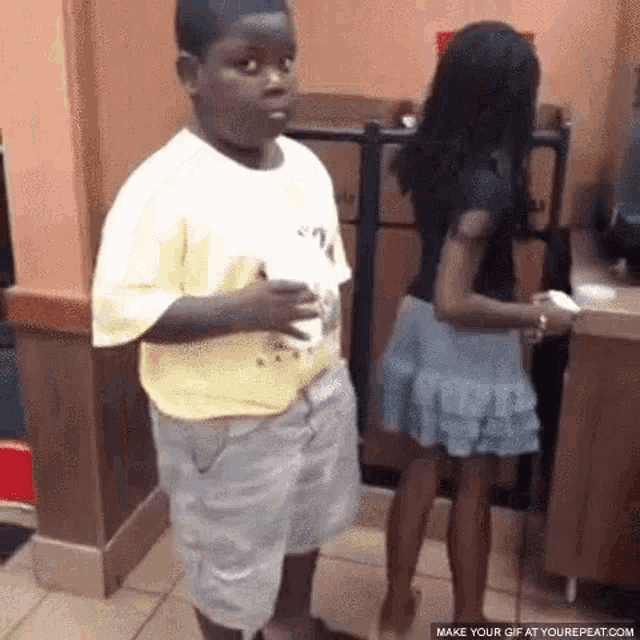 a boy and a girl are standing next to each other in a room .