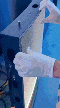a person wearing white gloves is cleaning a device
