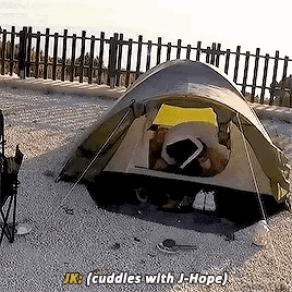 a person in a tent with the words jk cuddles with j-hope below them