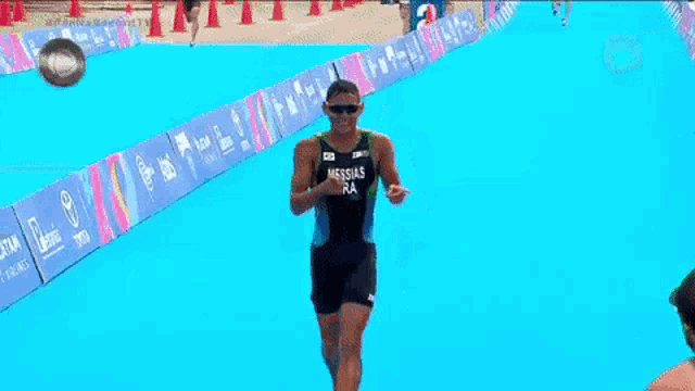 two athletes are shaking hands on a blue swimming pool .