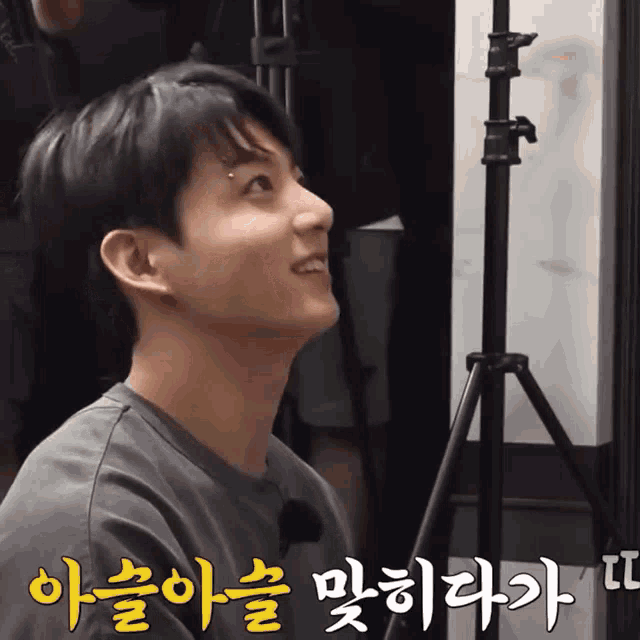 a man with korean writing on his face looks up at something