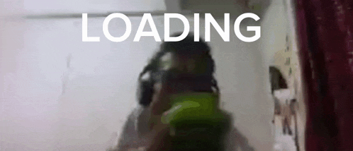 a blurry picture of a person wearing headphones with the words loading behind them .