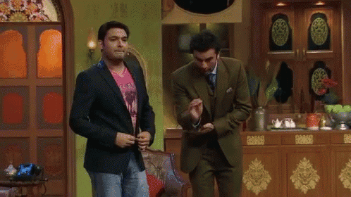 a man in a suit and a man in a pink shirt are standing next to each other