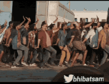 a group of people are dancing in front of a building with a twitter logo behind them