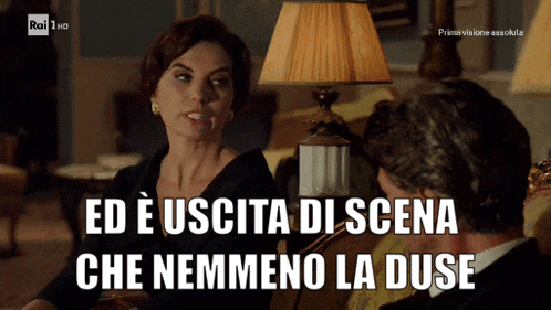 a man and a woman are sitting in front of a lamp and the woman says ed e uscita di scena