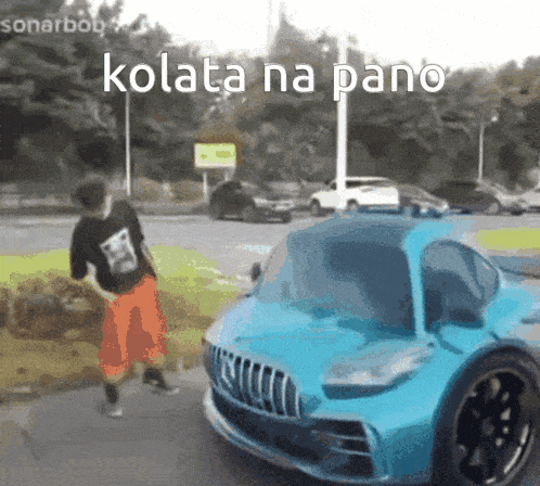 a man is standing next to a blue car that says kolata na pano on it