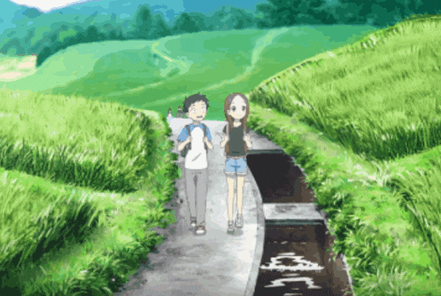 a boy and a girl are walking down a path surrounded by grass