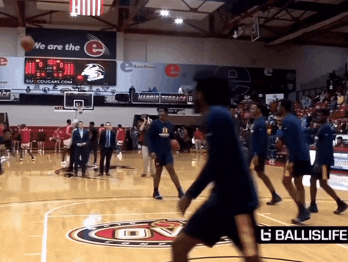 a group of basketball players on a court with a ballislife ad