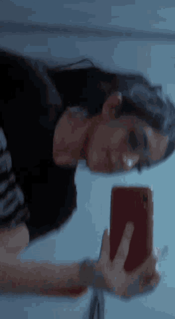 a woman is taking a selfie in a mirror with her phone .