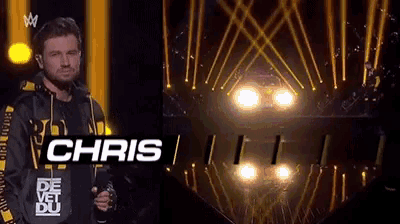 a man is standing on a stage with the name chris on his shirt