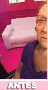 a woman is taking a selfie in front of a white couch in a room .
