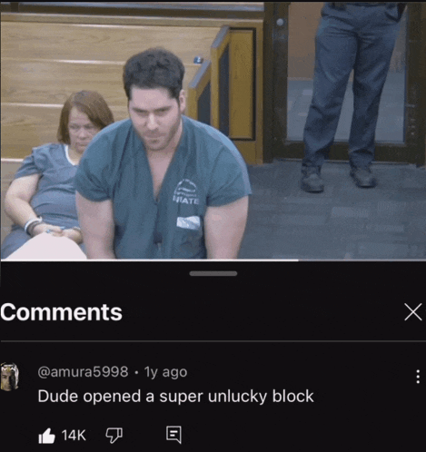 a man in a green state scrub is sitting in a courtroom with a woman