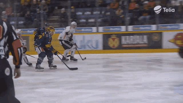 a hockey game is being played in front of a telia sign